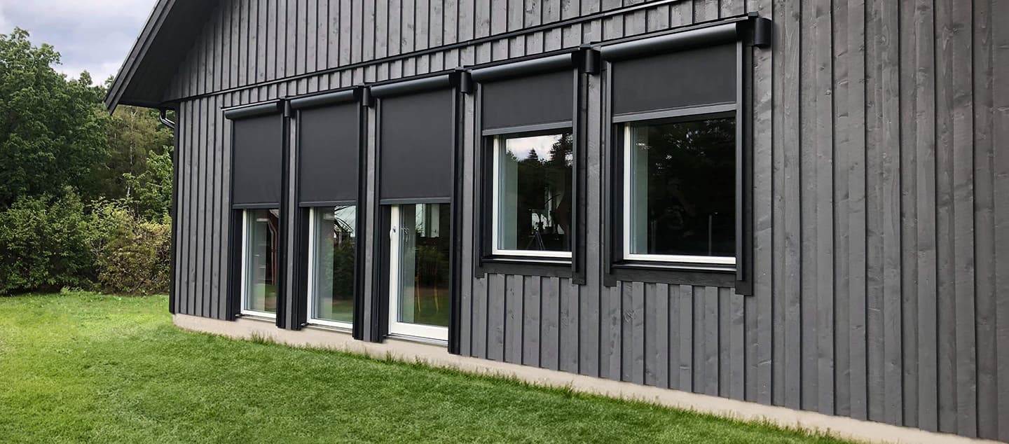 Svarta screenmarkiser på svart hus