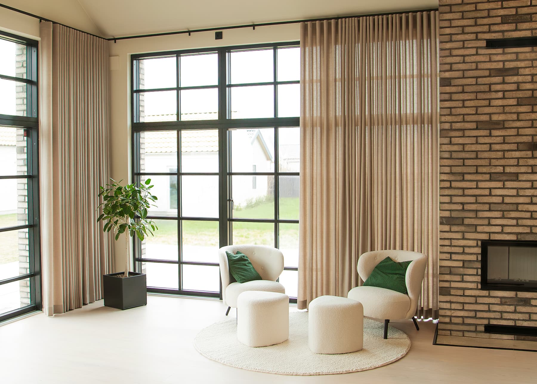 Modernt vardagsrum högt tak stora fönster svart spröjs takgardiner i beige tyg