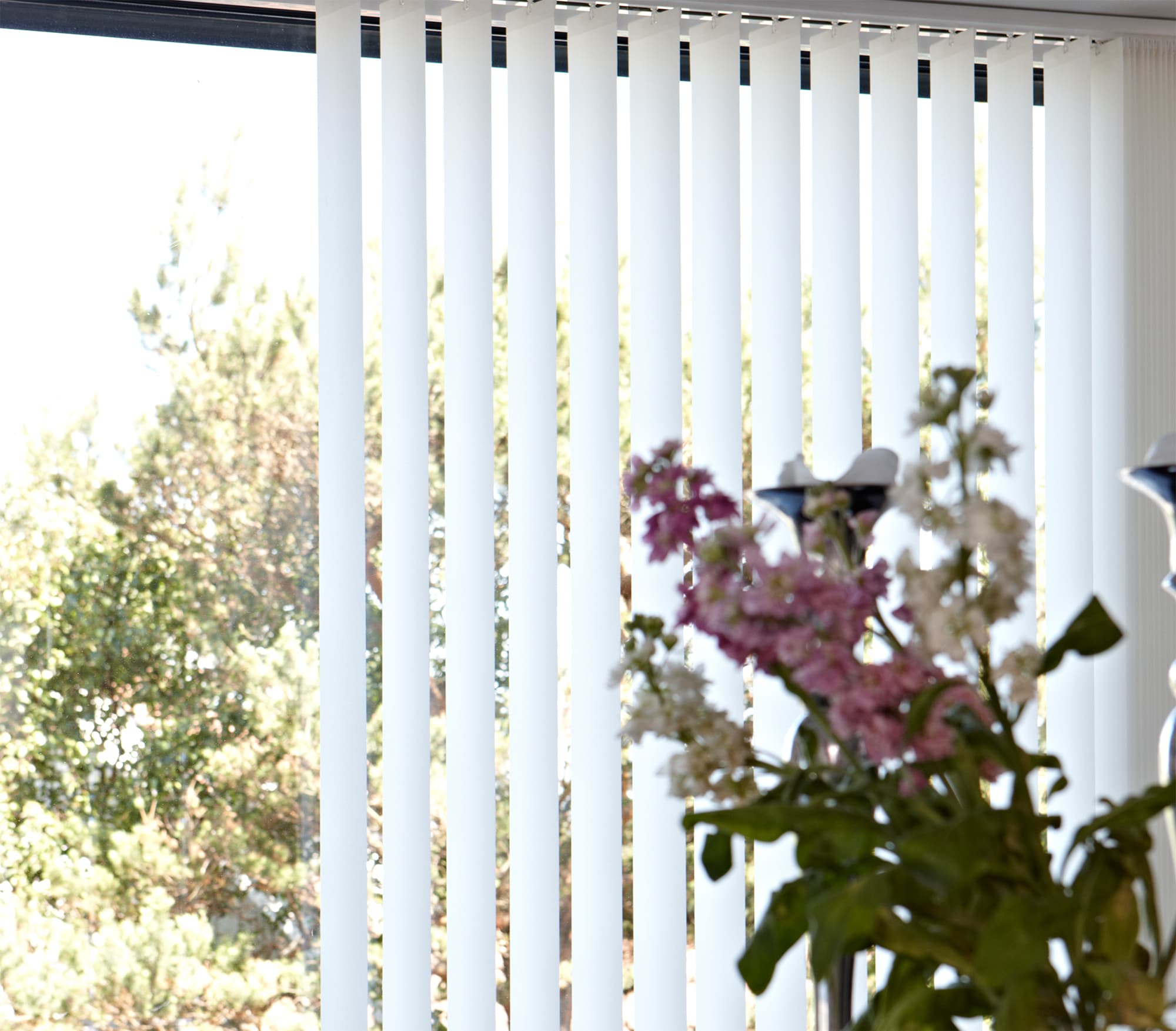 Lamellgardin ljuskontroll insynsskydd Lamellgardin med en blomma i förgrunden