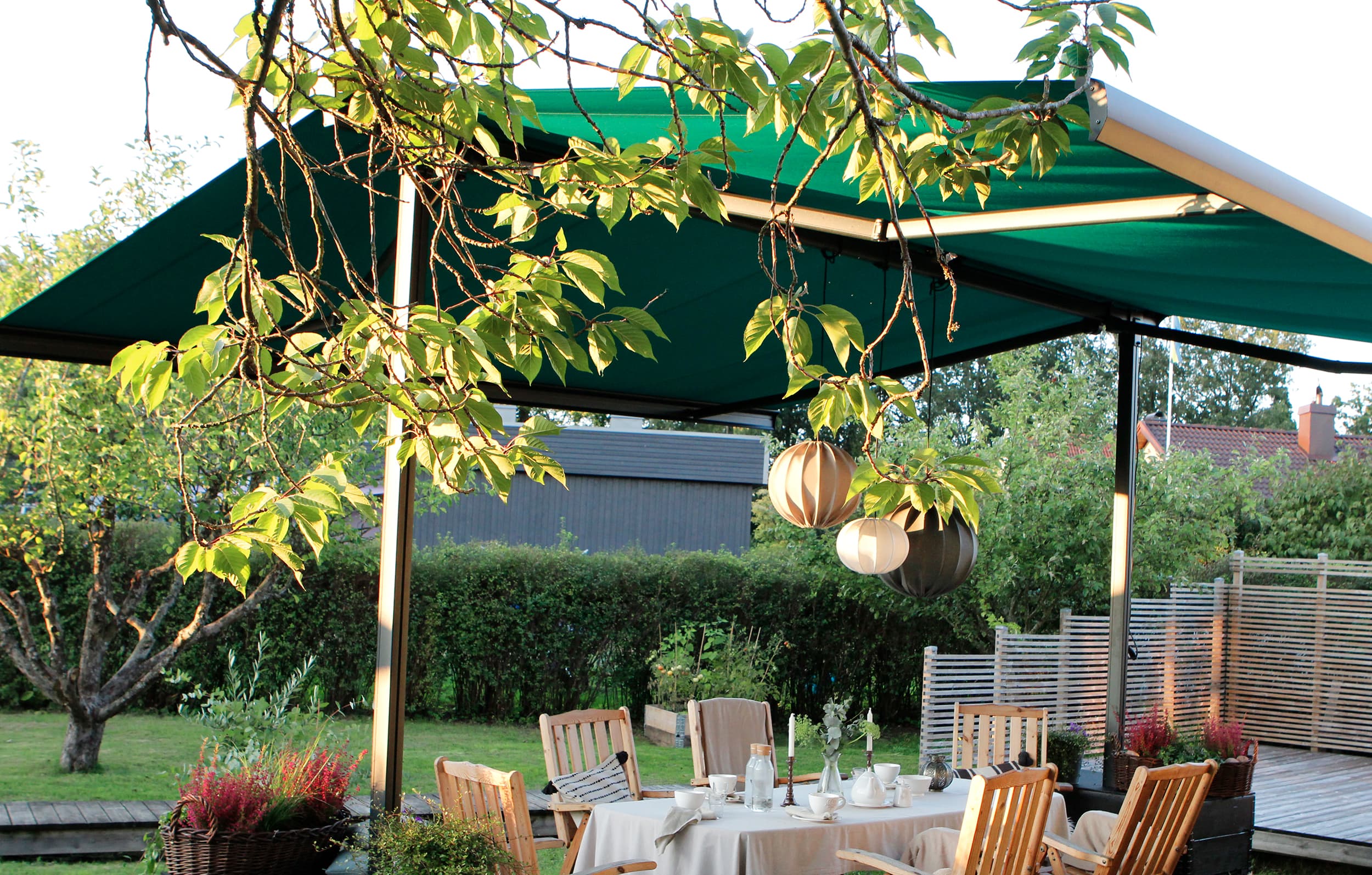 Trädgård utemiljö markis fristående solskydd Lummig trädgård med fristående markis över sittplats kvällssol solskydd